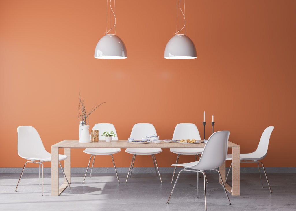 Orangefarbene Wand mit weißen Stühlen