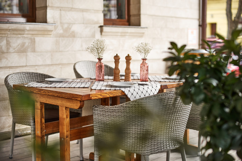 Sessel aus Polyrattan an einem Holztisch: Eine harmonische Kombination für deine Terrasse