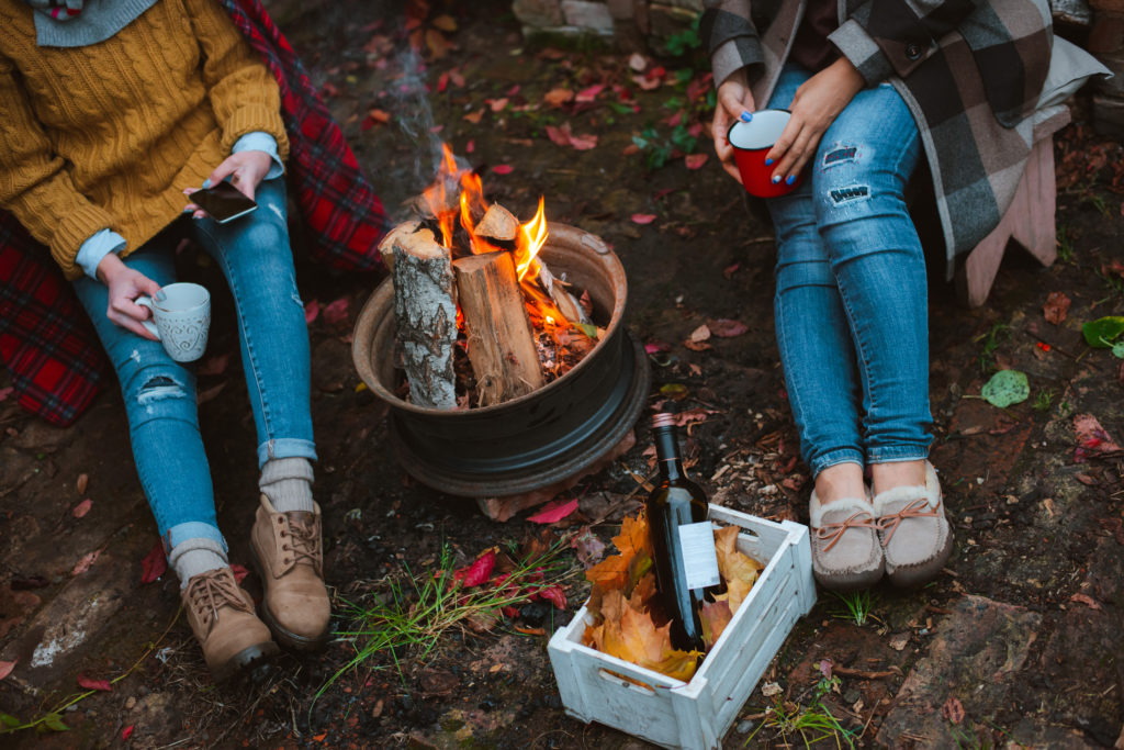 Herbst-Picknick im Wald mit einer Feuerschale und Wein