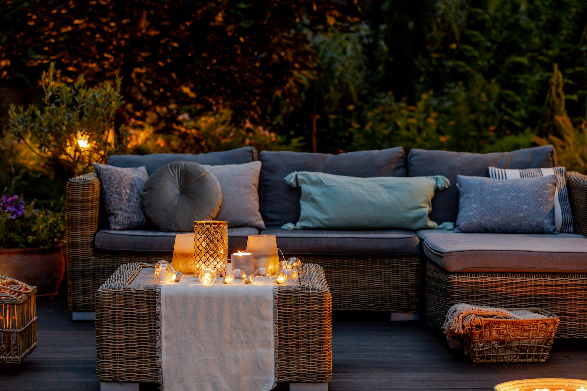 Outdoor Lounge mit gemütlichen Kissen, Decken und Kerzen für das Outdoor Cocooning