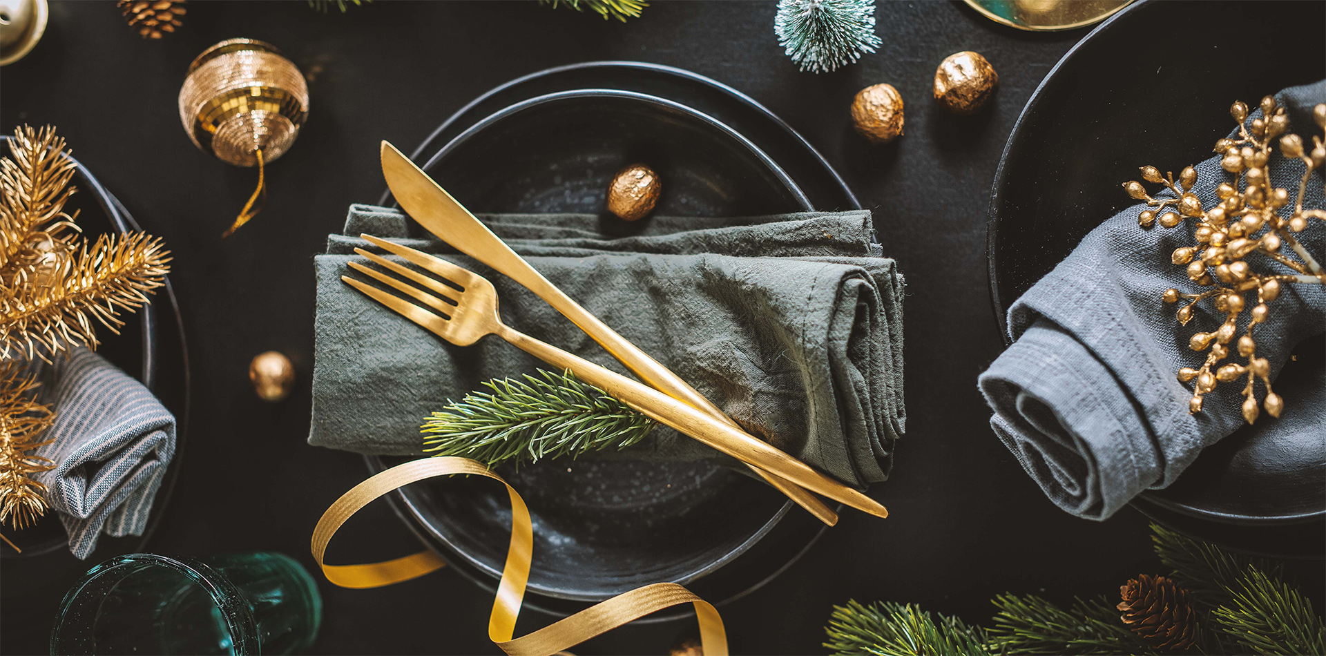 Tischdeko im Advent festlich geschmückte Tafel mit schwarzem Geschirr und goldenem Besteck