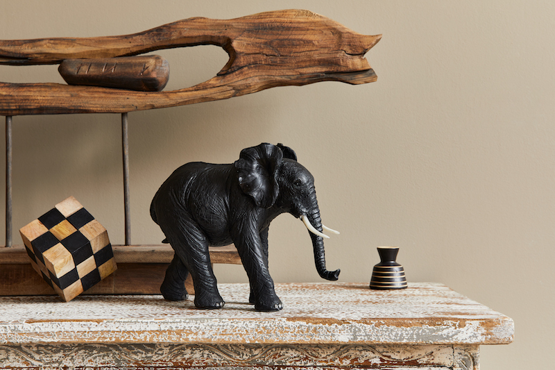 Detailansicht mit Wohnaccessoires im Kolonialstil, hier zu sehen eine schwarze Elefanten Figur