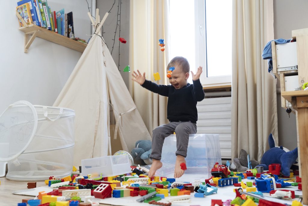Kind macht Chaos mit Legosteinen