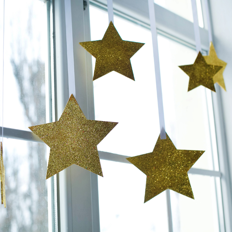 Goldene Sterne aus Pappe hängen am Fenster