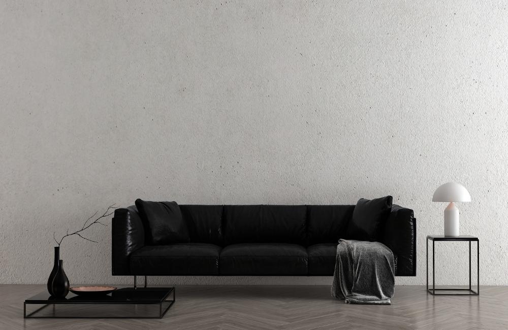 Schwarzes Sofa kombiniert mit grauer Wand und schwarzem Beistelltisch