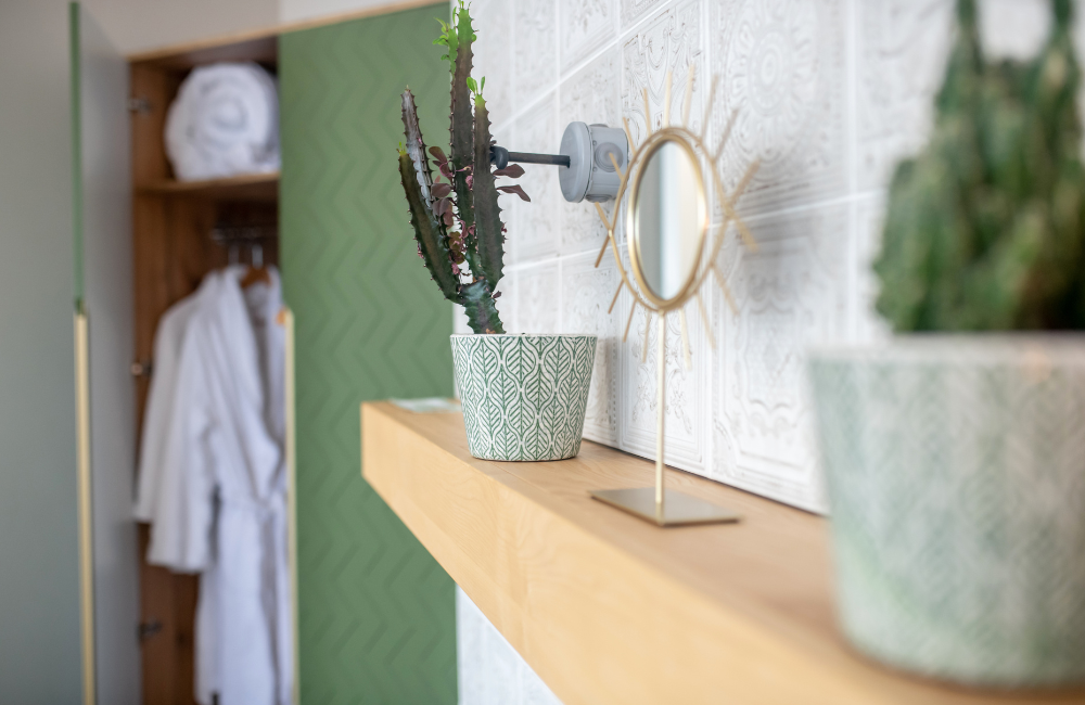 Wandregal aus Holz mit Pflanzen und einem dekorativen Spiegel als Blickfang